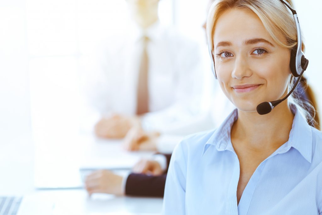 Group of diverse phone operators at work in sunny office.